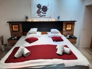 a bedroom with a large bed with red and white pillows at Exclusive Art Apartment in Krakow