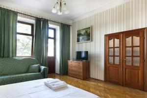 een slaapkamer met een bed, een bank en een televisie bij Centre 911 flat in Kiev