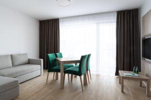 a living room with a table and green chairs at Green Apartments in Karpacz