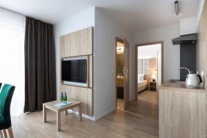 a living room with a television and a bathroom at Green Apartments in Karpacz