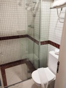 a bathroom with a toilet and a glass shower at Brasília Santana Gold Flat in São Paulo