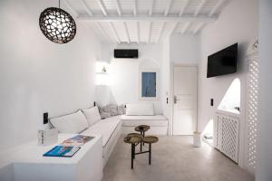 a white living room with a white couch and a table at Cloe Cycladic Residence, by Mykonos High in Mikonos