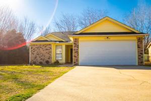 una casa amarilla con garaje blanco en Home Sweet Home in Camp Robinson, en North Little Rock