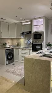 a kitchen with white cabinets and a counter top at برج داماك الجوهرة جدة - Damac al jawharah tower in Jeddah
