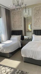 1 Schlafzimmer mit 2 Betten und einem Spiegel in der Unterkunft برج داماك الجوهرة جدة - Damac al jawharah tower in Dschidda