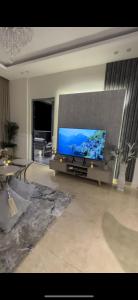 ein Wohnzimmer mit einem großen Flachbild-TV in der Unterkunft برج داماك الجوهرة جدة - Damac al jawharah tower in Dschidda