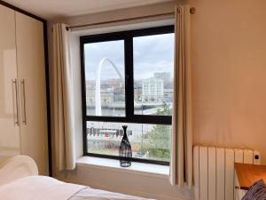 a bedroom with a window with a view of the gateway arch at Newcastle River View Quayside Apartment - Private Parking - Sleeps 7 - City Centre Walking Distance in Gateshead