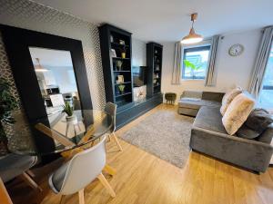 a living room with a glass table and a couch at Newcastle River View Quayside Apartment - Private Parking - Sleeps 7 - City Centre Walking Distance in Gateshead