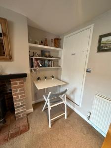 Habitación con escritorio y estante para libros. en Cottage en-suite room with private lounge, en Bridport