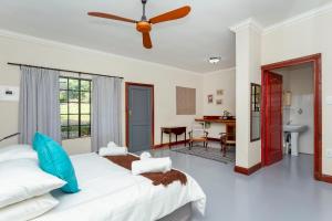 ein Schlafzimmer mit einem großen Bett und einem Schreibtisch in der Unterkunft Teak Place Guest Rooms in Krugersdorp