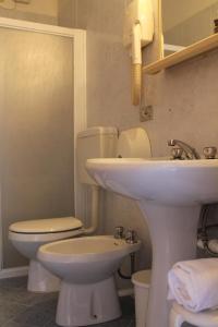 a bathroom with a white sink and a toilet at Hotel Vienna in Caorle