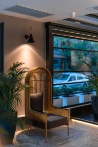 una silla de mimbre en una habitación con ventana en Ni Hotel Lara, en Antalya