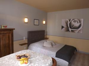 a bedroom with a bed with a bowl of fruit on it at HOTEL particulier LARIBOISIERE in Fougères