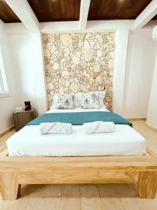 a bedroom with a large bed with a wooden bed frame at Oasis Tolú Hotel Boutique in Tolú