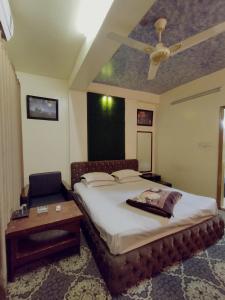 a bedroom with a bed and a table and a ceiling at Hotel Hoque Tower International in Chittagong