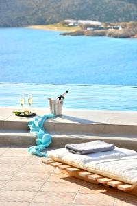 una piscina con una botella de vino y dos copas en Luxurious Villa Ostria, en Playa de Elia