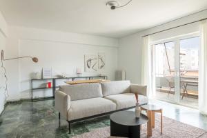 sala de estar con sofá y mesa en Outstanding 2BR Apartment in Cholargos by UPSTREET en Atenas