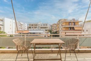 una mesa de madera y sillas en un balcón con edificios en Outstanding 2BR Apartment in Cholargos by UPSTREET en Athens