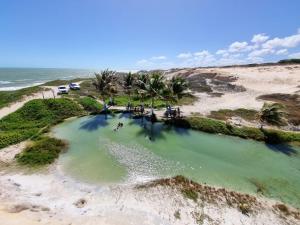 an aerial view of a pool of water on the beach at Duplex de 2 quartos com ar condicionado , piscina e estacionamento in Aracati