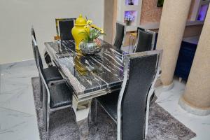 een eettafel met een gele vaas erop bij Pomaa Villa in Kumasi