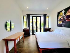 een slaapkamer met een wit bed en een houten tafel bij Delightful Romantic 4-BR Villa in Hội An