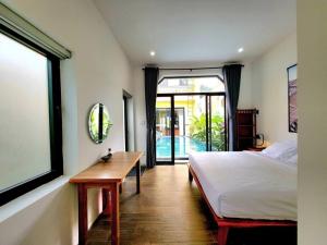 een slaapkamer met een bed, een tafel en een raam bij Delightful Romantic 4-BR Villa in Hội An