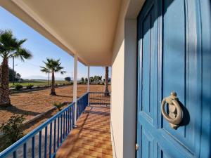 een blauwe deur op een huis met palmbomen bij Beachlife: The Bungalow in Kos-stad