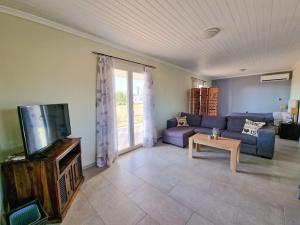 a living room with a couch and a tv at Beachlife: The Bungalow in Kos Town
