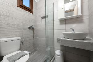 Baño blanco con lavabo y aseo en Aspa's House, en Limenas