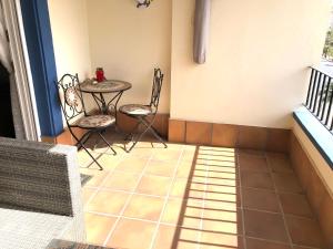 a small balcony with a table and chairs on a tiled floor at Marina Isla Canela apartment in Huelva