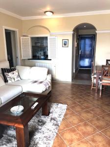 a living room with a white couch and a table at Marina Isla Canela apartment in Huelva