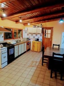 a large kitchen with a table and a counter top at Cuatro Cerros Hostel in San Carlos de Bariloche