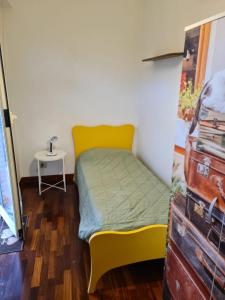 ローマにあるB&B Rome For Youの小さなベッドルーム(黄色のベッド1台、テーブル付)