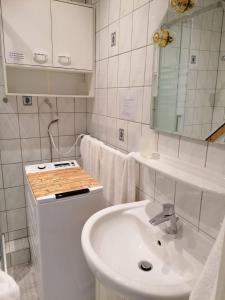 ein weißes Badezimmer mit einem Waschbecken und einem Spiegel in der Unterkunft SPO - gemütliches Apartment - TOP LAGE in Sankt Peter-Ording