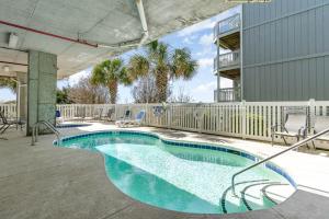 uma piscina com cadeiras e uma cerca em Spacious Penthouse Ocean Front 7 BR Condo - Ambassador Villas Unit 401 em Myrtle Beach