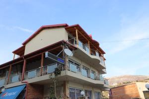 un edificio con balcones en un lateral en Fegi Rooms en Himare