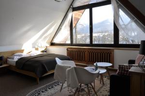 1 dormitorio con cama y ventana grande en B&B Art House Szymaszkowa 1, en Zakopane