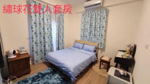 Schlafzimmer mit einem Bett mit blauen Vorhängen in der Unterkunft Flower B&B in Hualien