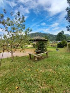einen Picknicktisch und einen Regenschirm auf einem Feld in der Unterkunft Casa de Campo Vó Almerinda in Urubici