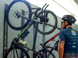 un homme tient un vélo sur un crémaillère dans l'établissement Diamant Hotel & Aparthotel, à Cala Ratjada