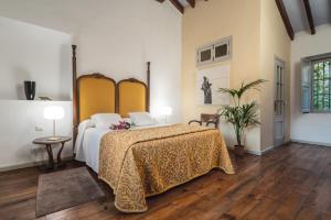 een slaapkamer met een groot bed met een gele sprei bij Art Boutique Hotel Chamarel in Denia
