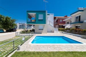 a villa with a swimming pool and a house at Danai & Palm Residential Complexes in Ofrínion