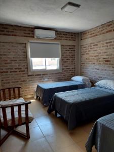 1 dormitorio con 2 camas y ventana en Salir del Cráter Apart in 