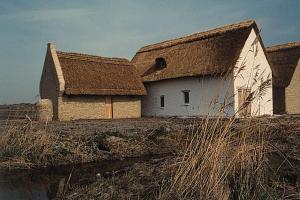 a large white barn with a roof on a field at Ruim zonnig appartement op 50m van strand in Ostend