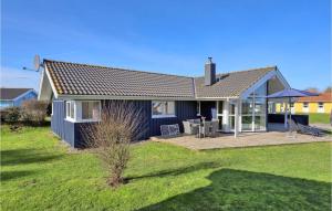 ein blaues Haus mit einer Terrasse im Hof in der Unterkunft Strandblick 23 in Schönhagen