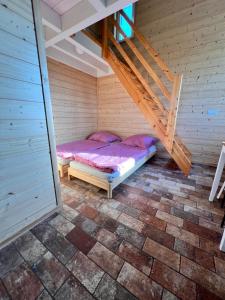 a small bed in a room with a staircase at EMSLAND-CAMP 