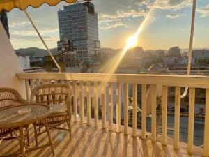 balcón con mesa, sillas y vistas a la ciudad en RTSH Apartment, en Tirana
