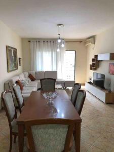 sala de estar con mesa con sillas y sofá en RTSH Apartment, en Tirana