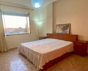 Un dormitorio con una cama grande y una ventana en RTSH Apartment, en Tirana