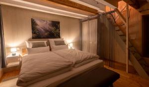 een groot bed in een kamer met een trap bij Servus Almtal in Scharnstein